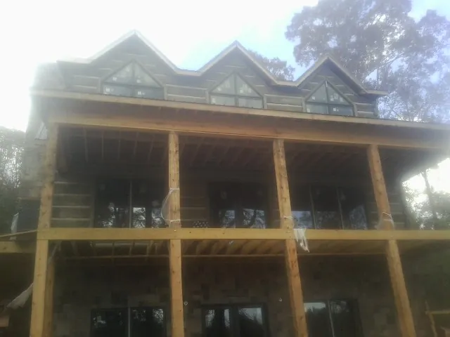 Dormers and porch framing on a large log home under construction — Roof Coating work by our crew in Van Wert